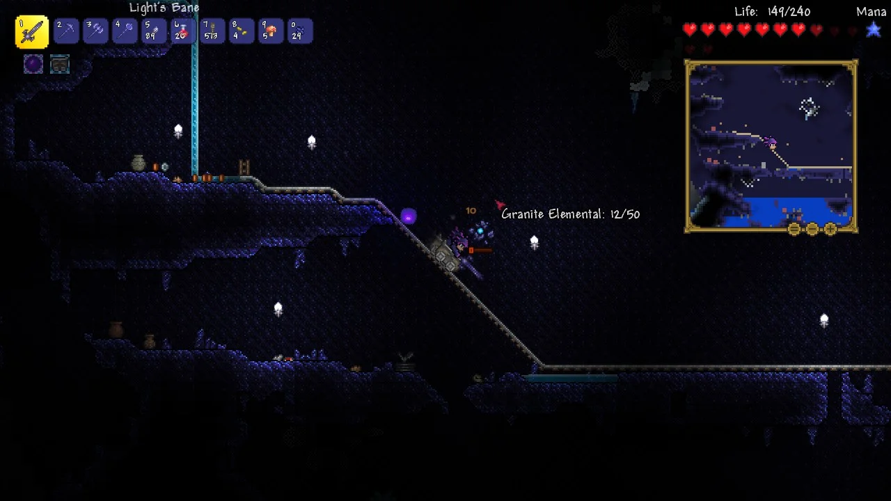 An early minecart rail running through a granite cave — the underground is where Life Crystals and ore live